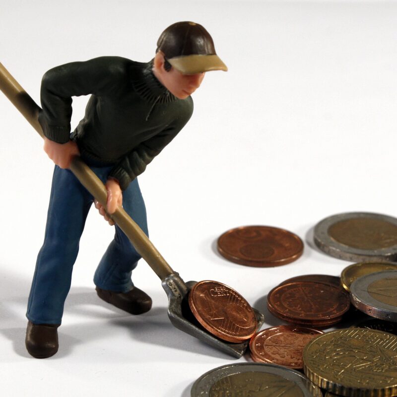 Miniature figurine of man shovelling coins