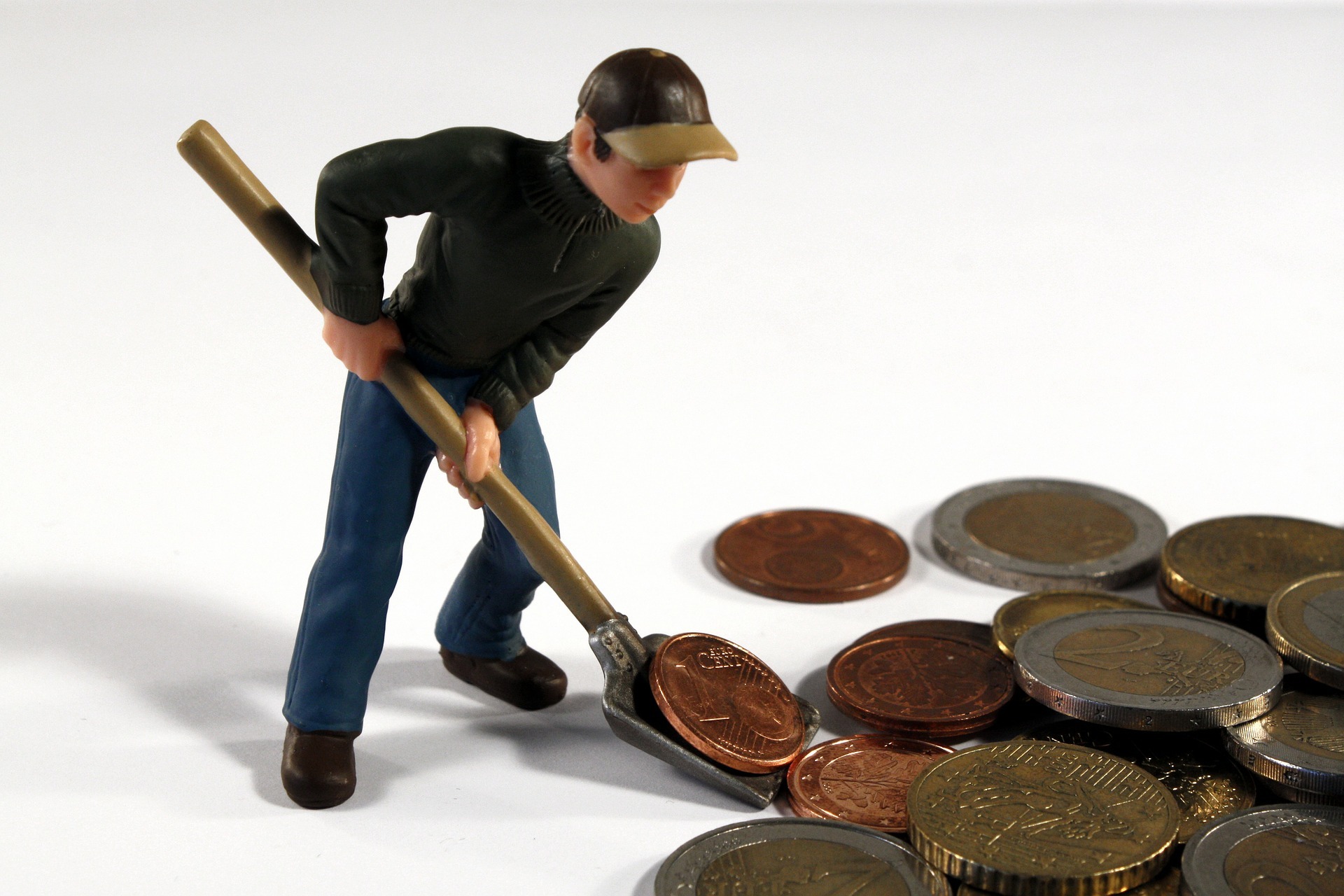 Miniature figurine of man shovelling coins