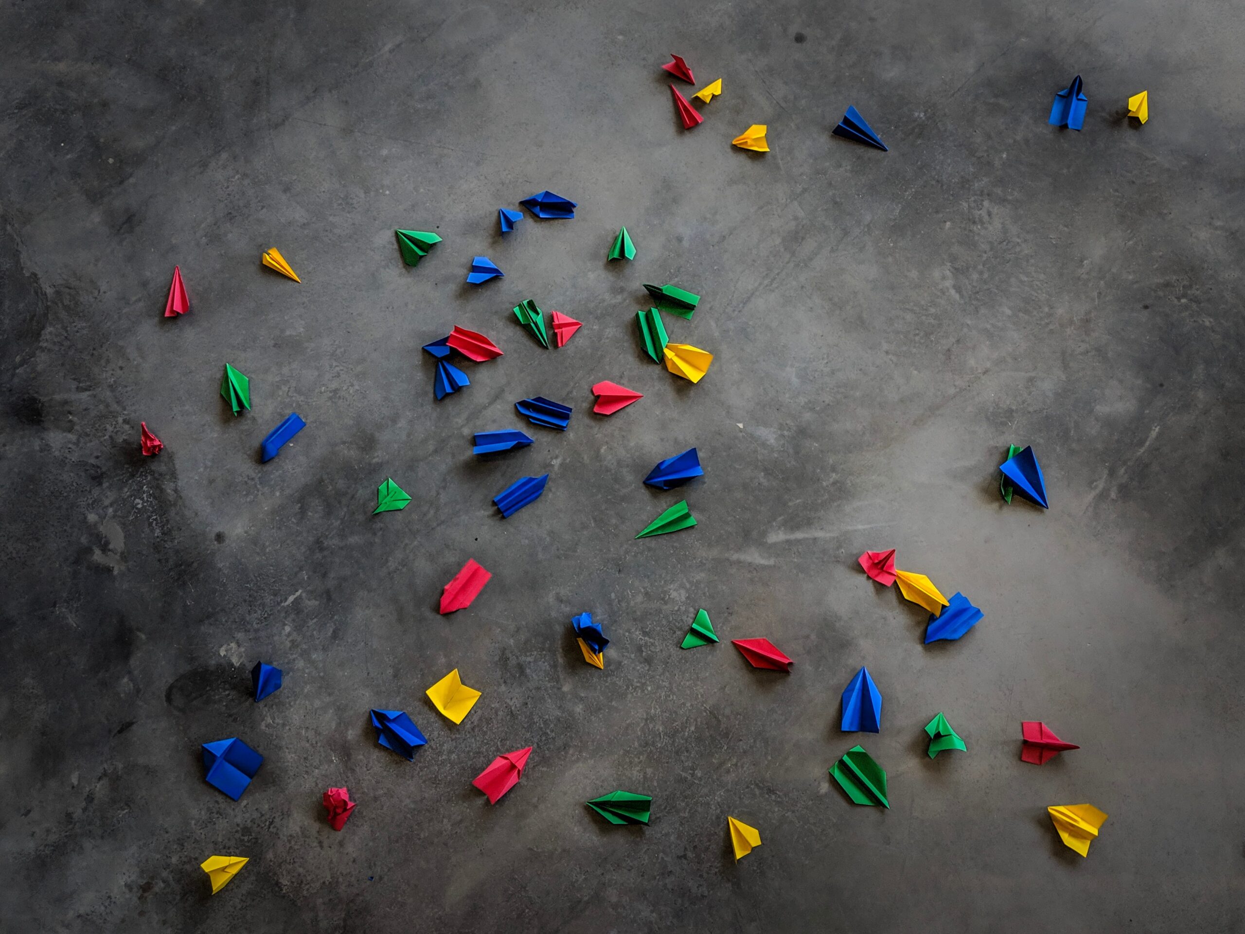 Tiny paper airplanes in the Google logo colours scattered on the floor