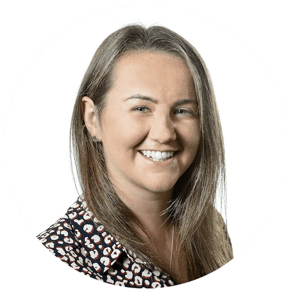 Smiling woman with long brown hair wearing a dark leopard-print top, professional headshot on white background.