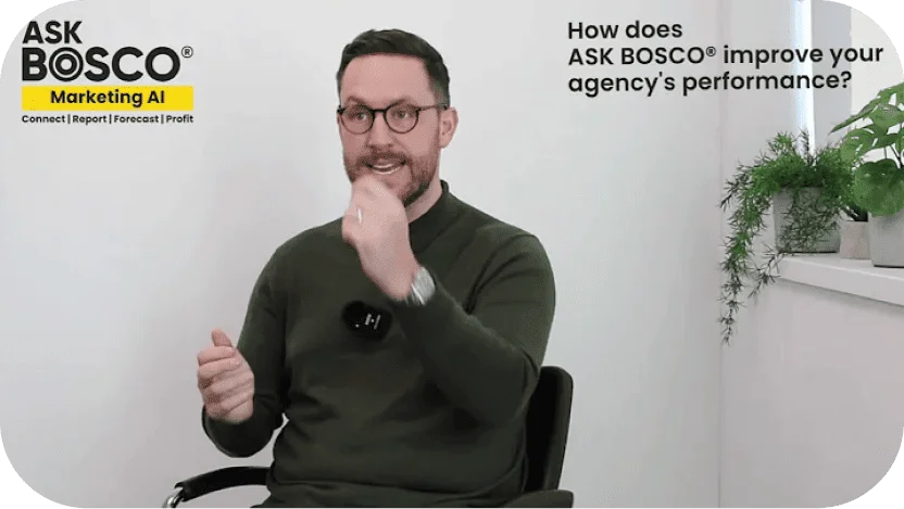 Man in a dark green sweater gestures while speaking in a video about how ASK BOSCO improves agency performance.