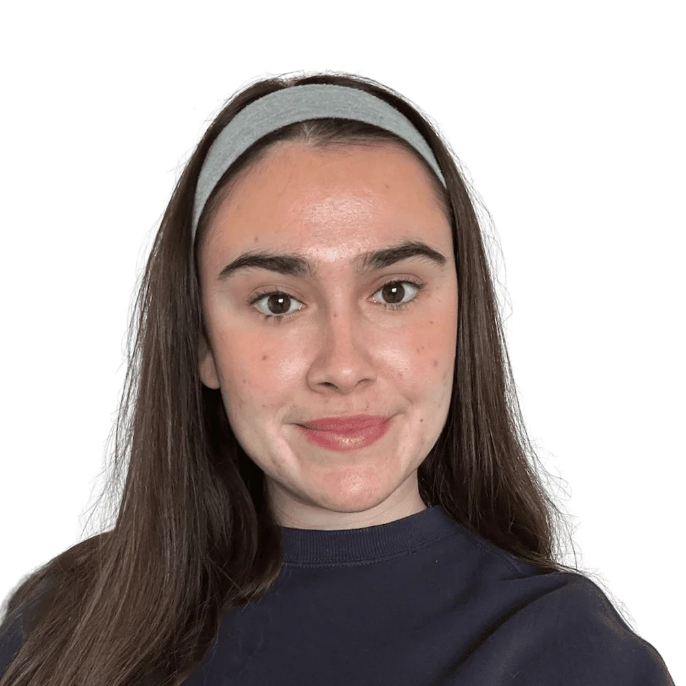 Creative Services team member, a woman with long brown hair and a gray headband, smiling at the camera.