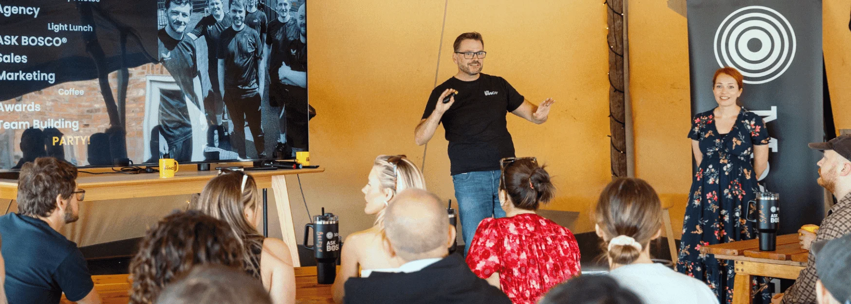 Speaker presenting to an audience at an Ask Bosco event, part of ongoing events and webinars.